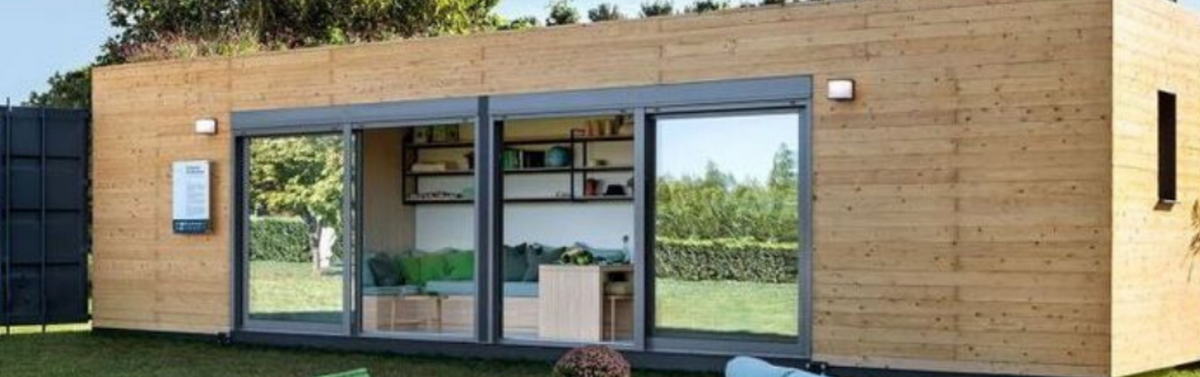 Module container habillé de bois clair, larges baies vitrées ouvertes sur un salon