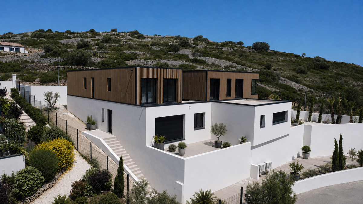 Maison container à Fitou, volume blanc surmonté d'un étage en bardage bois, adossée à une colline