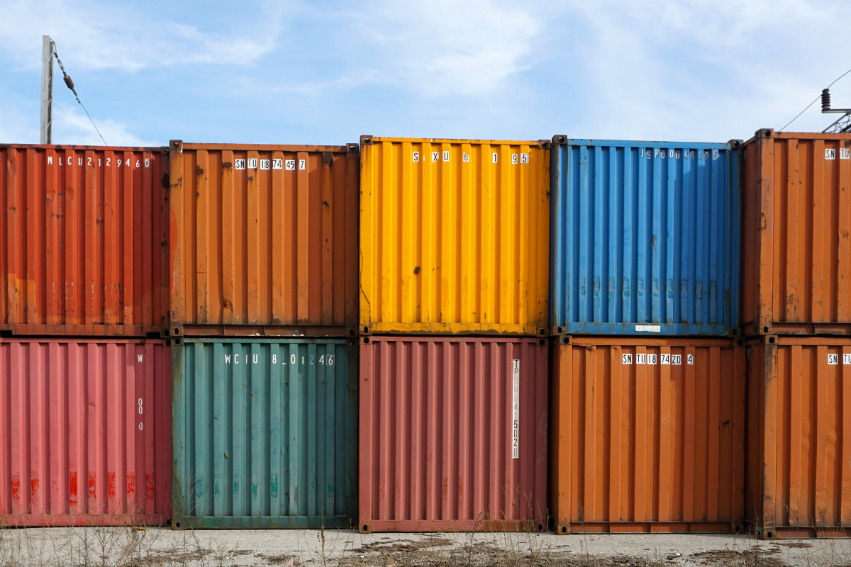 Containers maritimes colorés empilés sur deux niveaux devant un ciel bleu