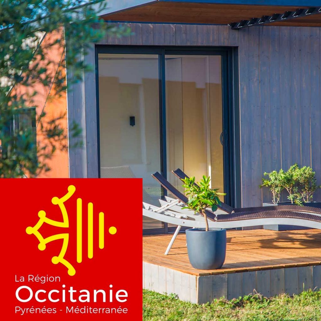 Studio container en bois avec bain de soleil sur la terrasse, logo de la Région Occitanie