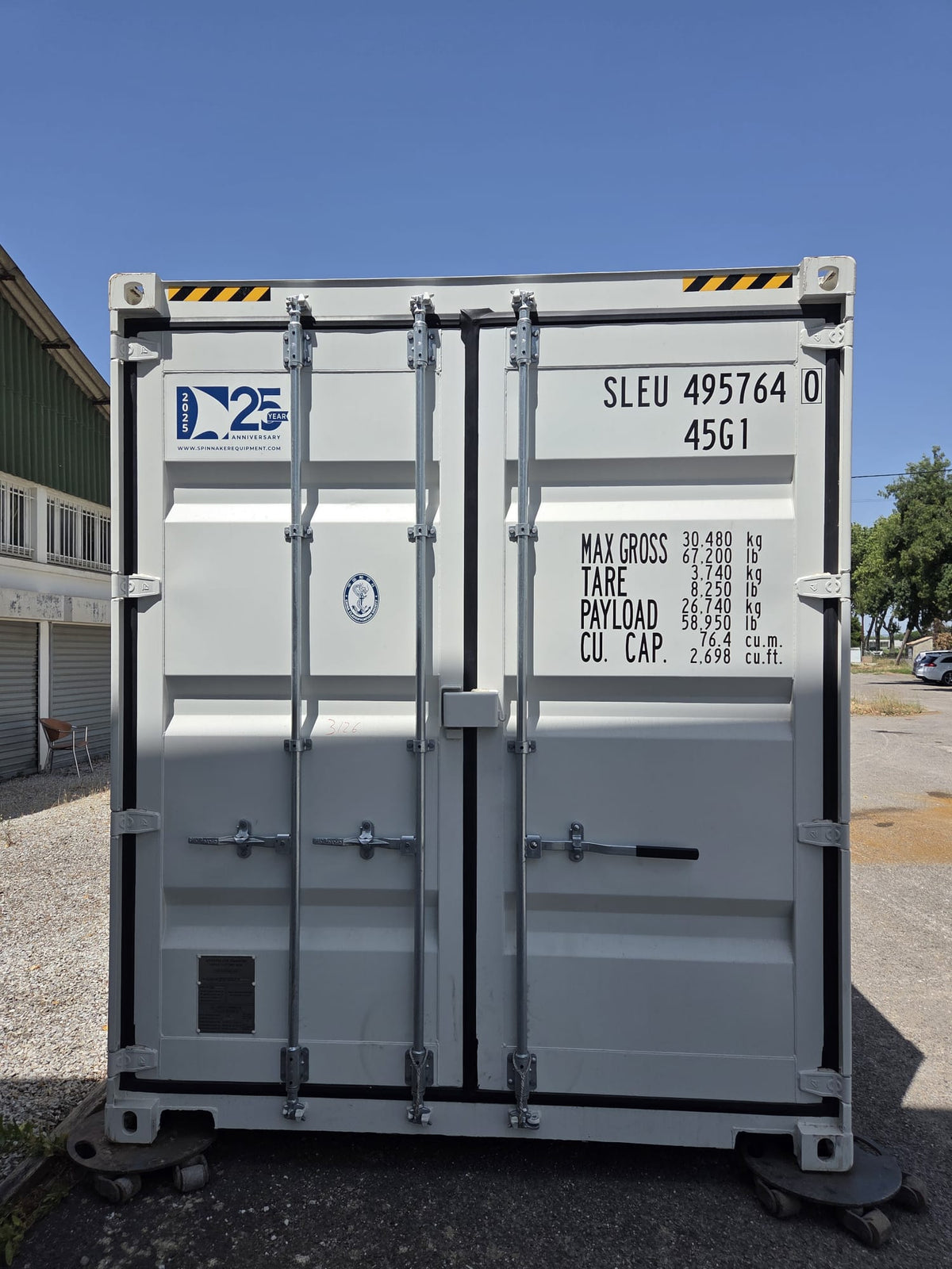 Container maritime 40 pieds High Cube gris clair vu de face devant l'atelier Contain Life à Trèbes, portes fermées à barres de verrouillage verticales et marquages de charge d'origine