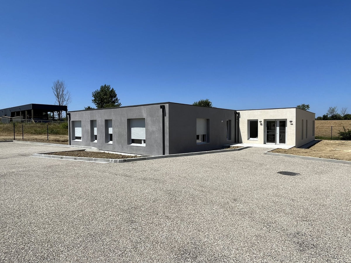 Façade du CMPP de Carcassonne en containers maritimes, enduit gris anthracite et volume d'entrée en enduit clair