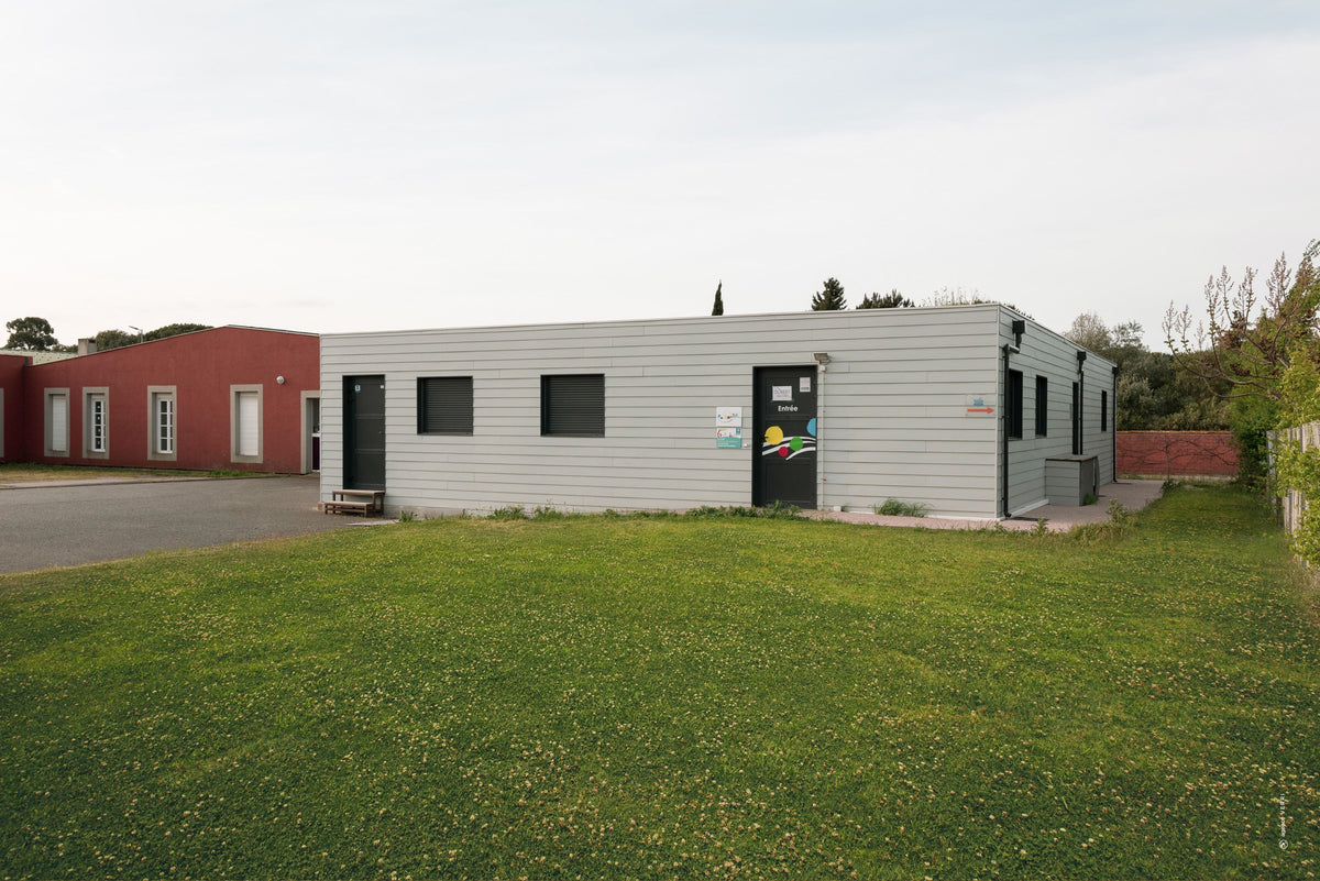 Maison de la famille en containers maritimes à Carcassonne, bardage à clins horizontaux gris vert et porte d'entrée anthracite