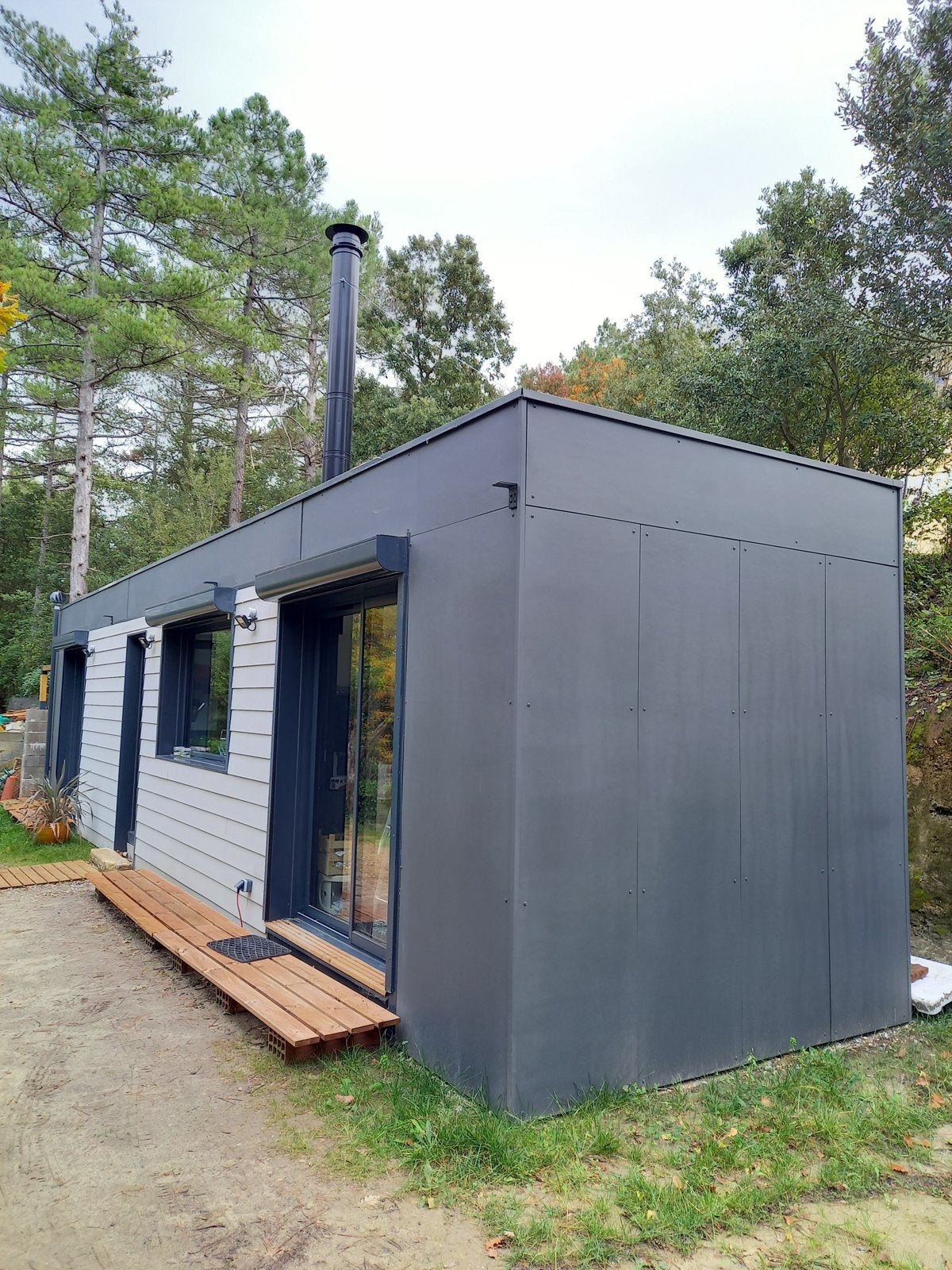 Maison container de 28 m² à Palaja, près de Carcassonne : façade en fibrociment teinté anthracite et terrasse en bois